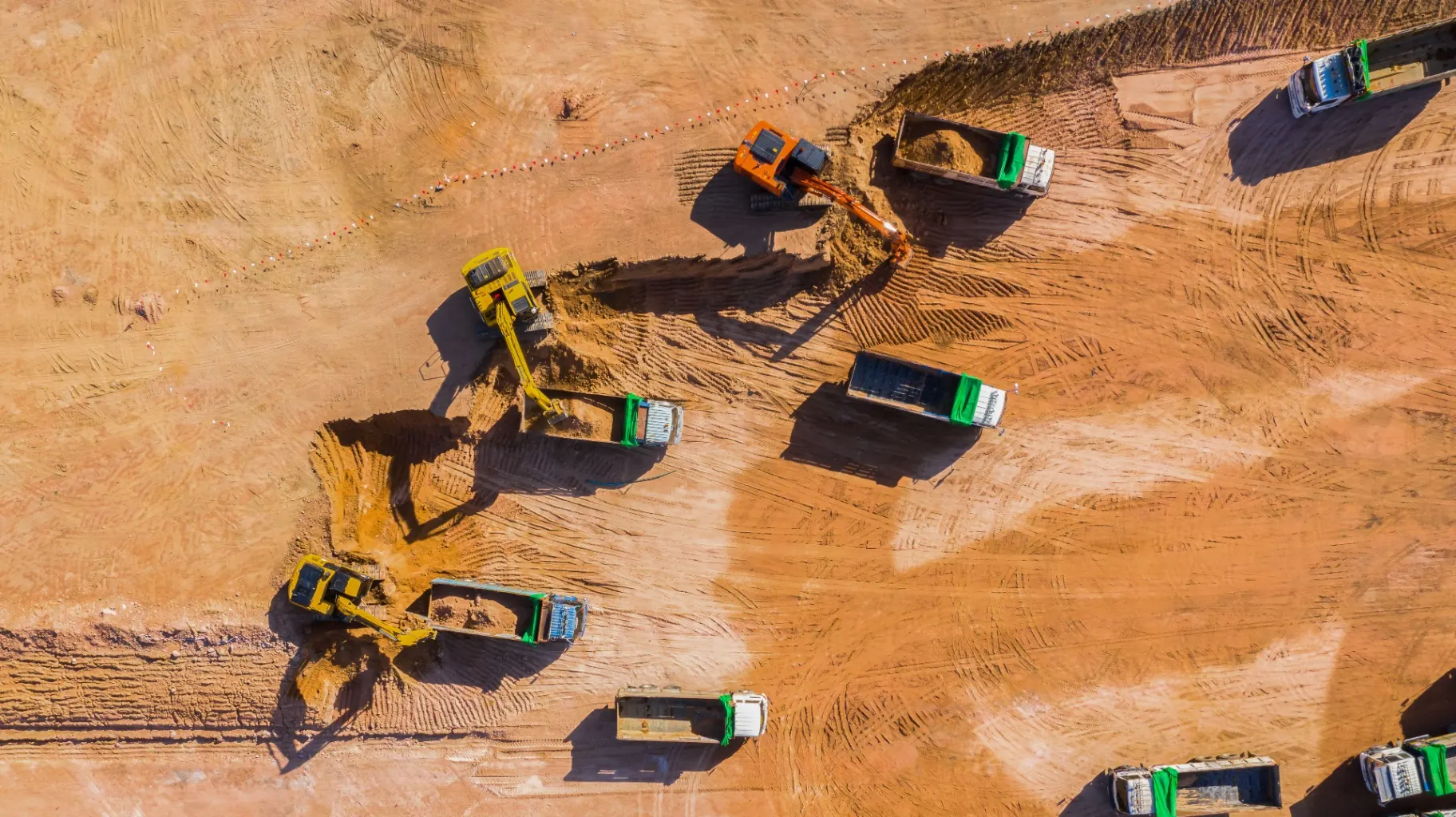 A working fleet of excavators, loaders and haul trucks across a job site